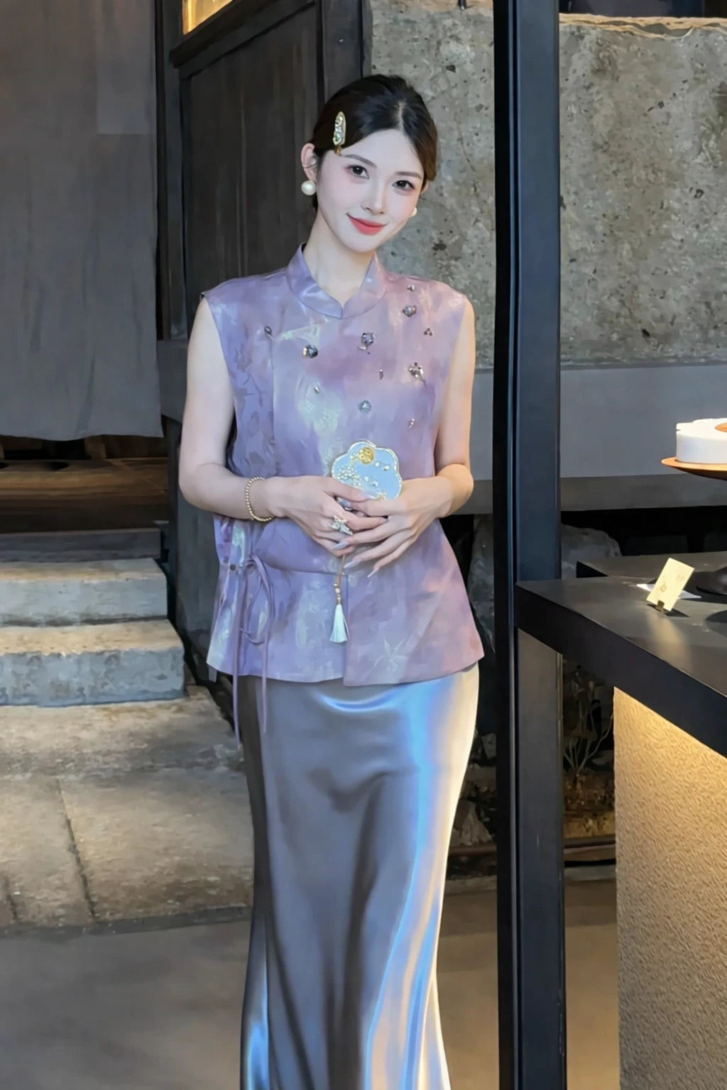 Model in a smoky purple satin midi skirt styled with a purple top and pearl shoes, showcasing the smooth drape and sophisticated look.