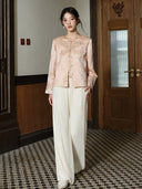 Front view of a model wearing the soft peach pink jacket with an embroidered neckline and cuffs.