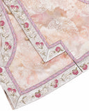 Close-up of the vest hem showing berry-and-blossom embroidery, patterned trim and decorative buttons.