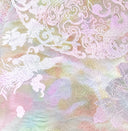 Macro view of the pastel jacquard pattern with floral medallions in pink, lilac and gold.