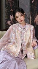 Seated model wearing the embroidered pink-gold vest with a smoky pink top and lilac skirt.