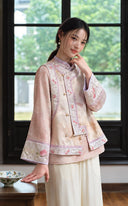 Model by a window wearing the pink-gold vest with embroidered trim and a smoky pink inner top.