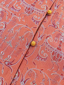 Close-up of the gold-toned buttons and red scrolling jacquard motifs