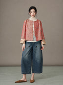 Model wearing the crimson jacket over a cream top with wide-leg denim trousers