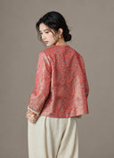 Back view of the model wearing the crimson jacquard jacket with contrasting embroidered cuffs