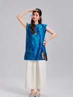 Woman wearing a vintage blue polka dot Xiangyunsha silk top with ruffled shoulders