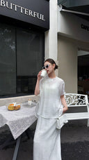 Front view of a women's white Qipao blouse and skirt set, featuring a mandarin collar and button detail, styled with sunglasses and a white handbag.