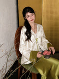 Close-up of a white green acetate bamboo jacket with V-neckline, button front, regular long sleeves, and matcha green cuffs.