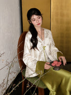 Close-up of a white green acetate bamboo jacket with V-neckline, button front, regular long sleeves, and matcha green cuffs.
