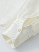 Close-up of the cuff detail on a white jacquard blouse, showing the fine stitching and button finish, crafted from a premium Viscose-Silk blend.