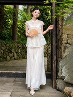 Model in a white lace Cheongsam top, standing outdoors with a fan, showcasing the breathable Viscose-Polyamide blend and elegant fit.
