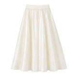 Flat lay of a white shiny maxi skirt with an elastic waistband and flowy silhouette, crafted from 100% polyester.