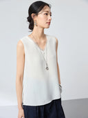 Side profile of a white V-neck sleeveless silk blend vest, showcasing the comfortable fit, clean lines, and versatility as a layering piece.