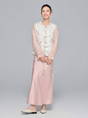 Full body shot of a model wearing a white New Chinese style Tencel vest over a pink sheer blouse and satin midi skirt, showcasing the elegant and graceful aesthetic.