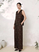 Side view of a women's silk Qipao set shown as a V-neck sleeveless vest layered over matching wide-leg pants, featuring intricate green floral brocade on a wine red base.