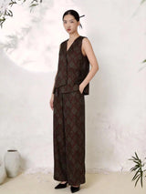 Side view of a women's silk Qipao set shown as a V-neck sleeveless vest layered over matching wide-leg pants, featuring intricate green floral brocade on a wine red base.