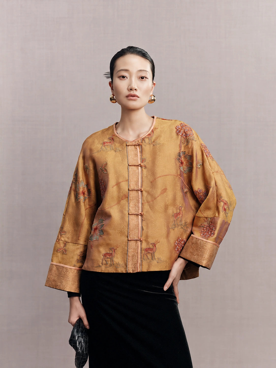 Front view of a women’s antique gold New Chinese silk jacket with a round neck and button closure