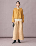 Beige high-waisted jacquard wide-leg pants styled with a gold New Chinese jacket