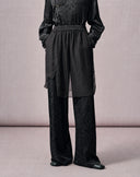 Close view of women’s black full-length jacquard pants with a relaxed wide-leg silhouette