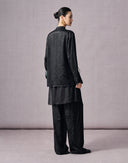 Back view of a women’s black rayon jacquard shirt and relaxed wide-leg pants