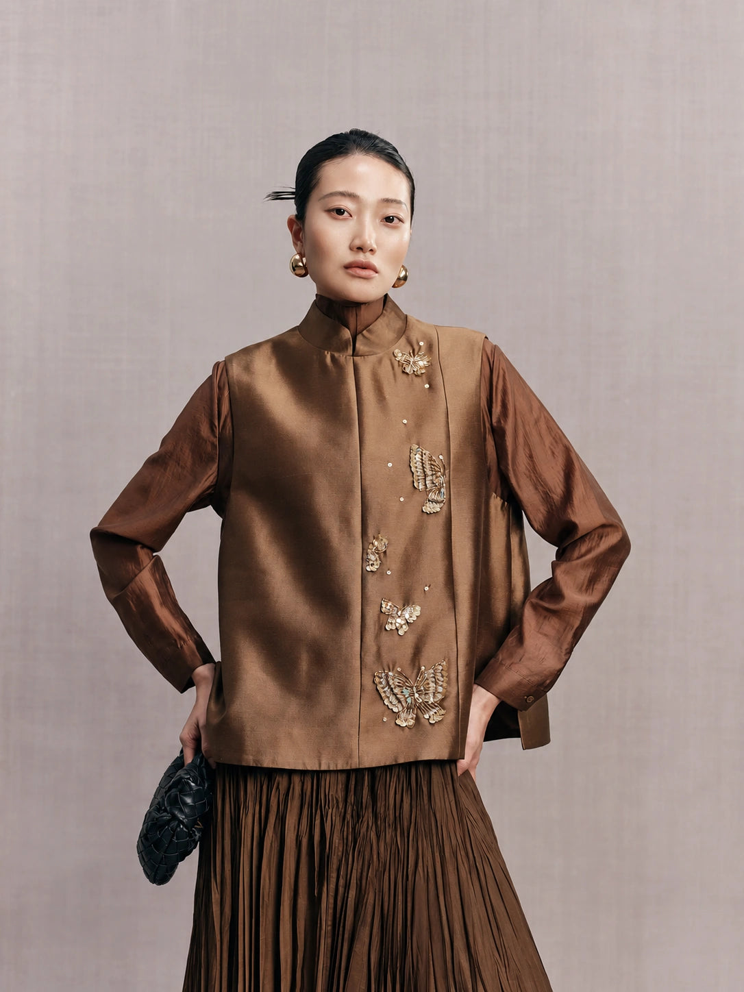 Front view of a bronze brown New Chinese vest with a stand collar and embellished butterflies