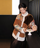 Woman wearing a brown patchwork jacket with velvet and colorful Shu brocade panels