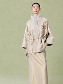 Front view of the linen two-piece set showing the jacket’s tie waist and floral embroidery