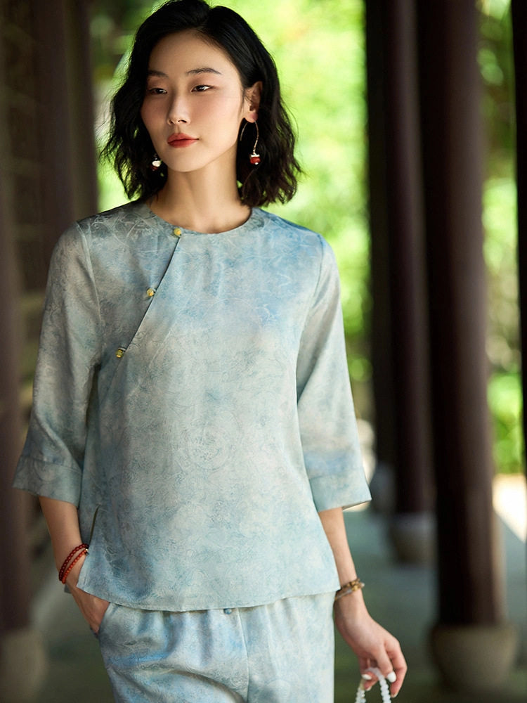 Front view of a relaxed light blue mulberry silk blouse with a round neck and three-quarter sleeves