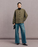Olive green frog-button jacket styled with a black top and wide-leg jeans