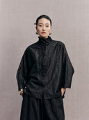 Front view of the black crackle-pattern side of the reversible New Chinese jacket