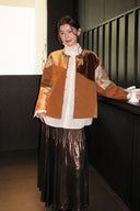 Front view of the brown patchwork jacket worn open over a white blouse