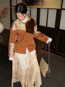 Front view of the brown button-front jacket with asymmetrical velvet and brocade panels