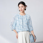 Sky blue 100% mulberry silk blouse styled with a white skirt and blue handbag