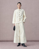 Woman wearing white jacquard wide-leg pants with a matching New Chinese button-front jacket