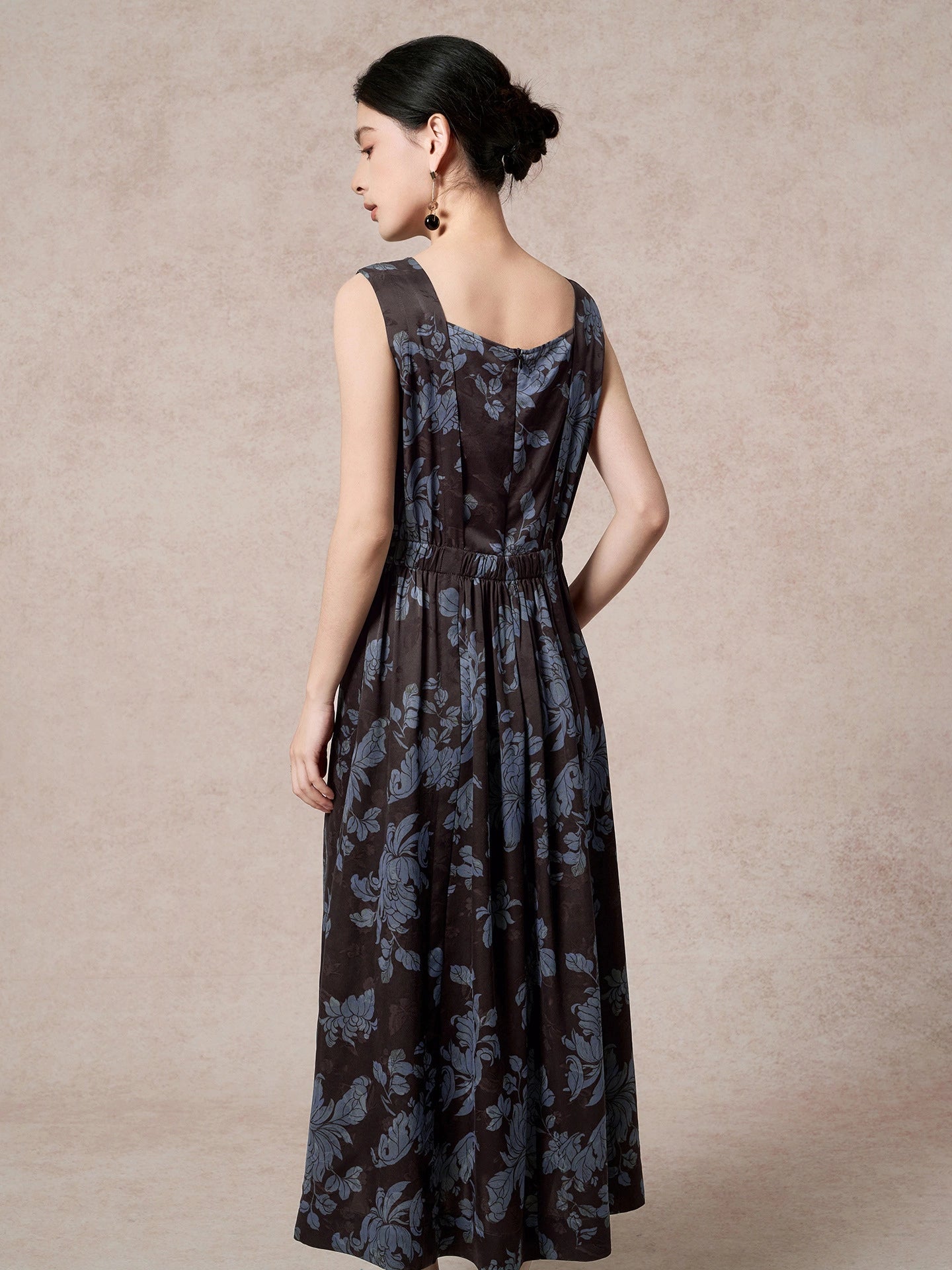 Back view of a brown 100% mulberry silk Xiangyunsha dress with blue floral jacquard, featuring a gathered waist, back zipper, and a flowing A-line skirt.
