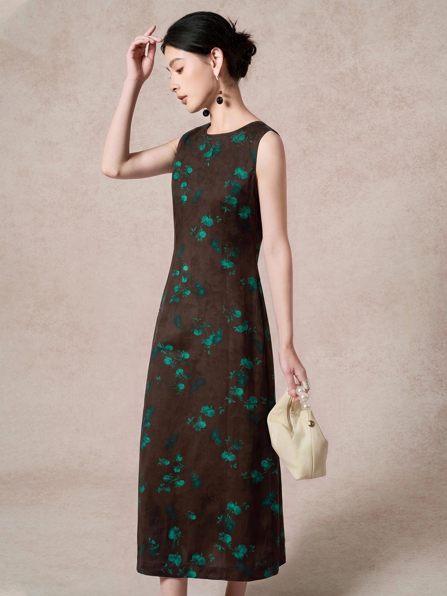 Side view of a brown 100% mulberry silk sleeveless dress with a round neckline and green floral jacquard pattern, showcasing the elegant A-line silhouette.