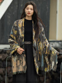 Front view of the draped cashmere shawl detail in gray, teal, and ochre over the black leather jacket