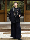 Full-length outfit featuring the Yanchuan embroidered jacket and dark wide-leg trousers on a garden walkway.