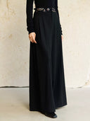 Front view of Yangui high-waisted pants showing the colorful embroidered waistband and deep pleats.