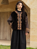 Front view of the Yanrong jacket with black shearling panels, patterned silk sleeves, and ornate embroidered trim