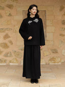 Model wearing the relaxed black double-faced wool coat with a long skirt and black ankle boots