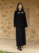 Yanshuang embroidered black wool coat styled with a flowing black skirt and heeled ankle boots