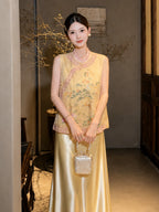 Model in a yellow sleeveless embroidered vest with a mandarin collar, holding a handbag, highlighting the intricate embroidery and elegant silhouette.