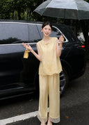 Model wearing a yellow embroidered Cheongsam vest with matching wide-leg pants, holding a clear umbrella in the rain, showcasing the elegant drape of the 73% Viscose and 27% Polyester blend.