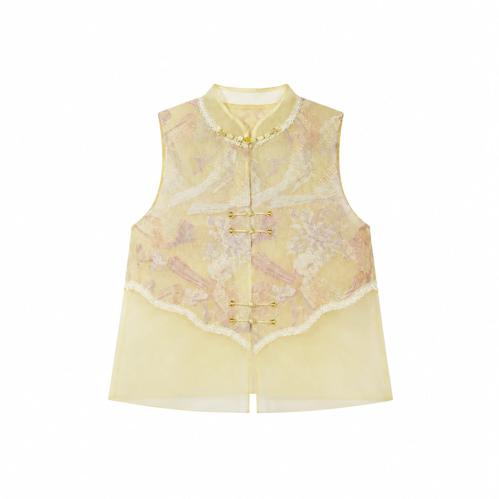 Flat lay of a yellow sleeveless vest with gold metallic buttons, lace trim, and a layered sheer hem, crafted from a Lyocell-metallic blend.
