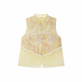 Flat lay of a yellow sleeveless vest with gold metallic buttons, lace trim, and a layered sheer hem, crafted from a Lyocell-metallic blend.