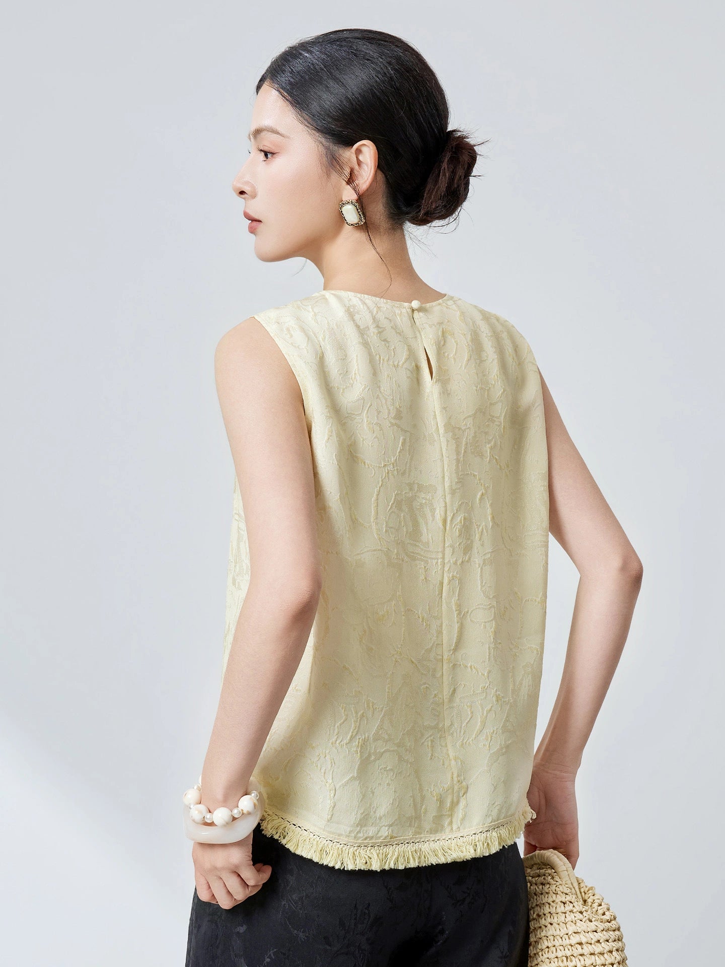 Side view of a pink silk top with a relaxed fit and jacquard texture, showcasing the elegant drape and handcrafted details.