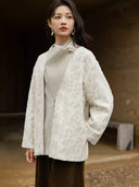 Yongyan ivory coat with the wool-blend front panel raised at the neckline, showing a gold-tone decorative accent
