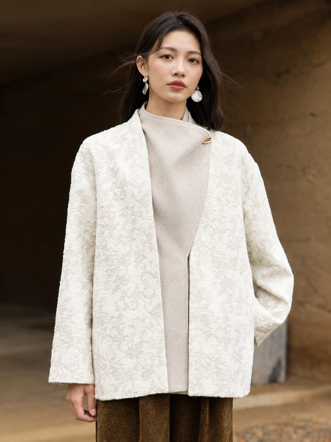 Front view of the Yongyan coat highlighting its textured ivory floral jacquard and contrasting wool-blend panel
