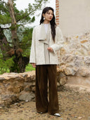 Three-quarter view of the ivory jacquard coat showing its relaxed fit, long sleeves, and contrasting folded front panel